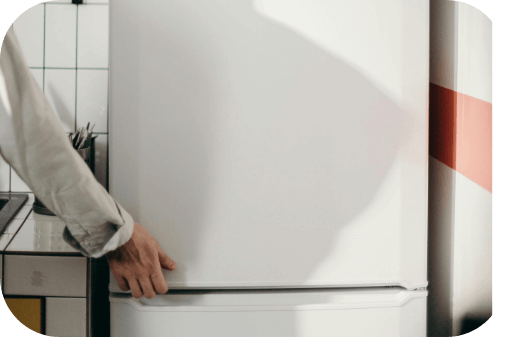Une main qui ouvre le frigo dans une cuisine