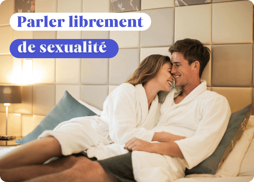 Un couple qui rigole en peignoir dans un lit