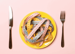 Une jeune femme inquiète observe un proche lors d'un repas afin de repérer les signes d'une anorexie mentale ou d'un trouble des conduites alimentaires.
