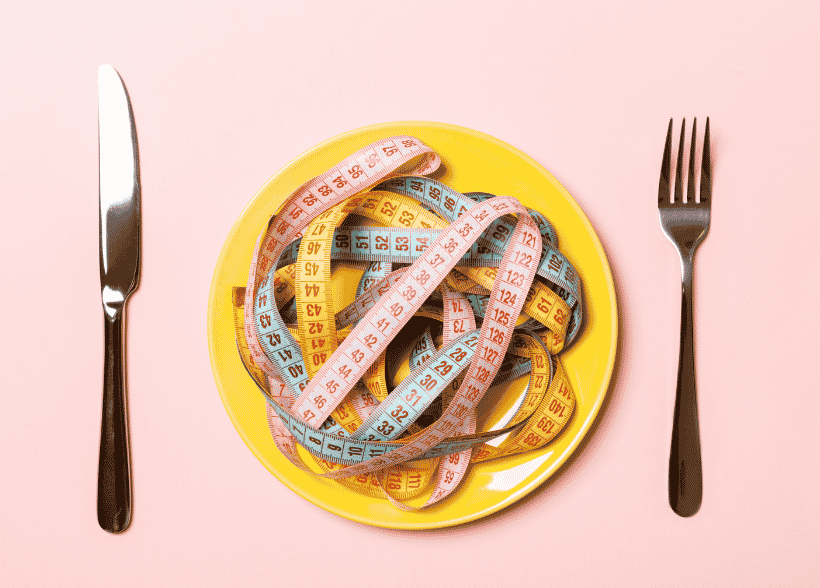 Une jeune femme inquiète observe un proche lors d'un repas afin de repérer les signes d'une anorexie mentale ou d'un trouble des conduites alimentaires.